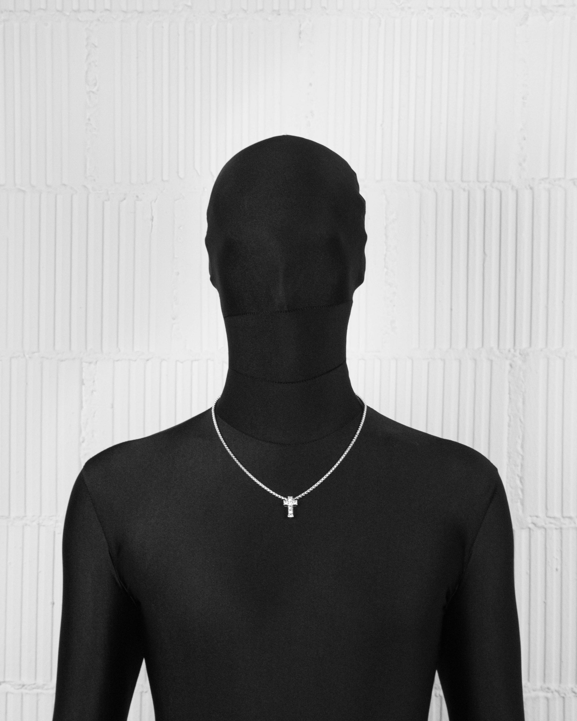man with black suit wearing 18k white gold coated cross pendant necklace with hand-set princess-cut stones in white and 3mm box chain