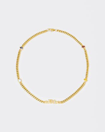 A Vibe cuban chain necklace with 18kt yellow gold coating, mixed shape bezel stones in diamond white, yellow, garnet, tanzanite and "A Vibe" central metal tag. Lobster clasp with logo