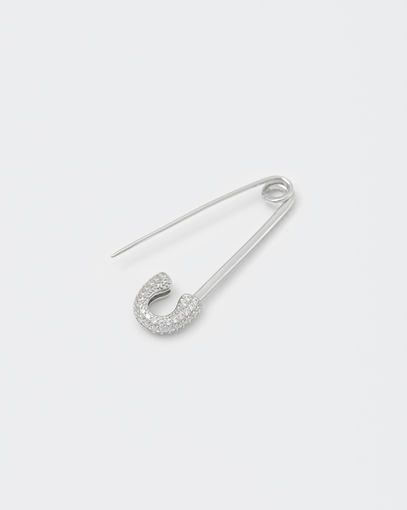 detail of 18k white gold coated safety pin mono earring with all-around hand-set micropavé stones in white